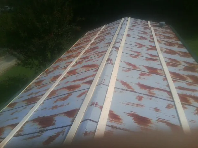 Rusted metal roof panels with new wood purlins before replacement — Storm Damage Roof Repair in Elkton by Roofing Brothers